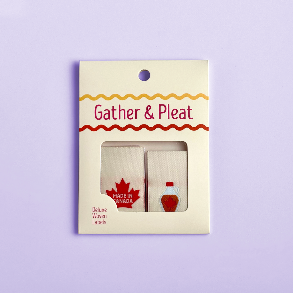 Pack of six 'Made in Canada' woven sewing labels in Gather & Pleat retail packaging, on a lilac background.